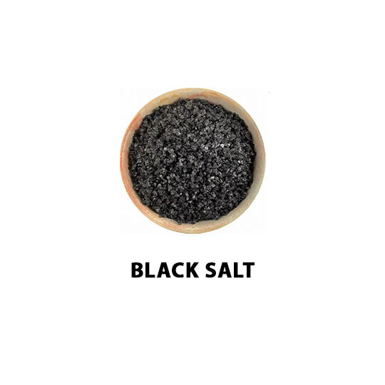 Wooden bowl filled with himalayan black salt on a white background